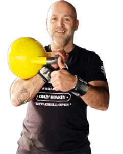Homme souriant tenant une kettlebell jaune.