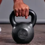Main tenant kettlebell de 16 kg au sol.