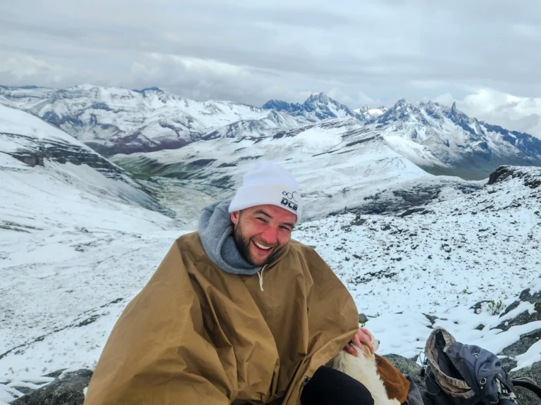Homme souriant en montagne enneigée